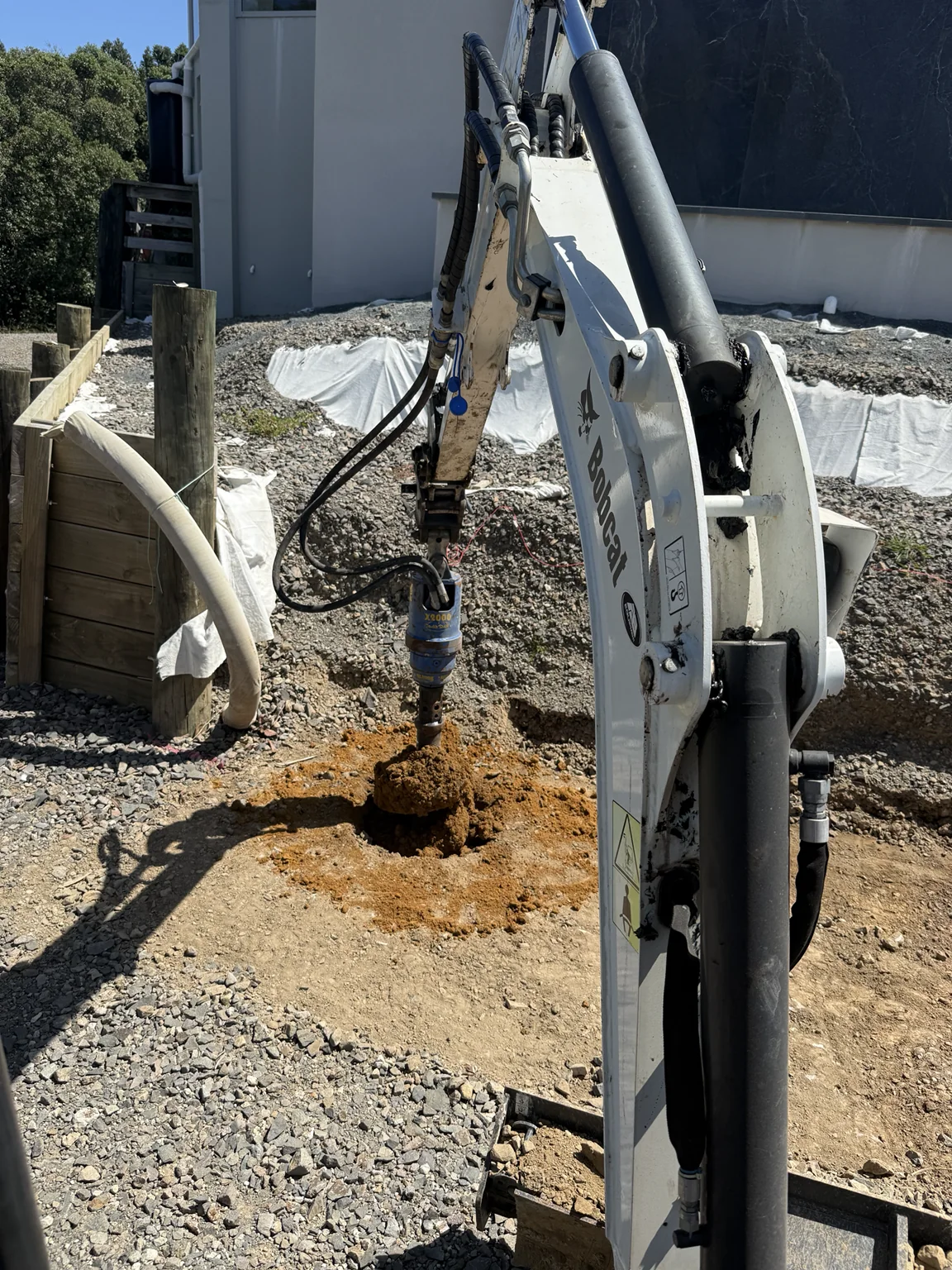 Excavator auger drilling at a Waikato residential worksite