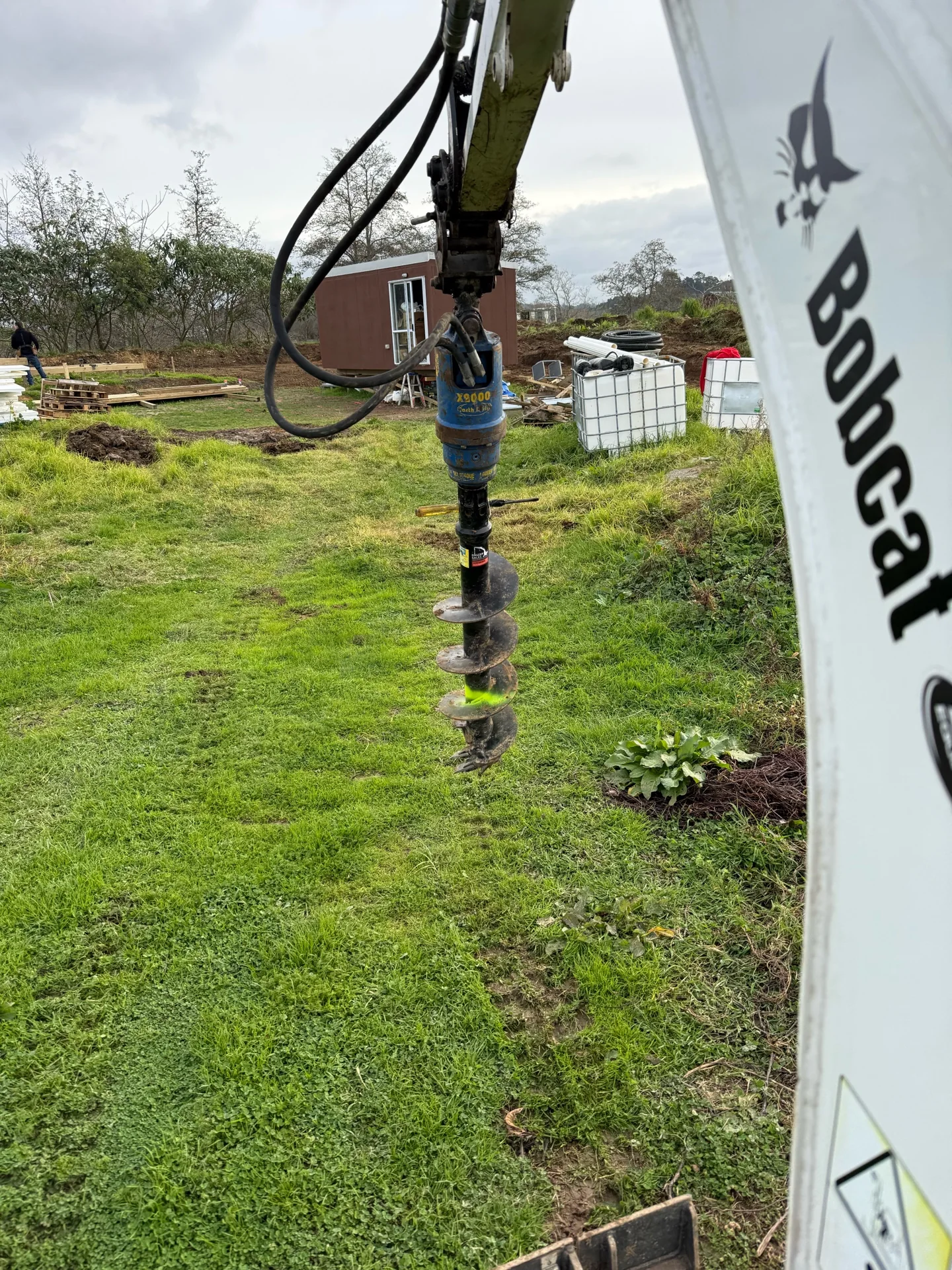 Auger attachment fitted to an excavator arm